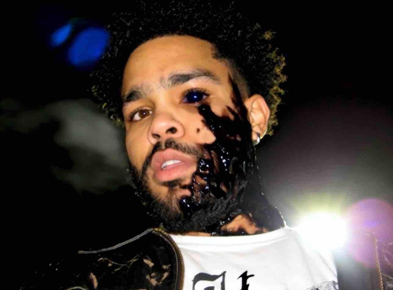 Color source portrait of Chris Shaw wearing a black-drip face treatment.
